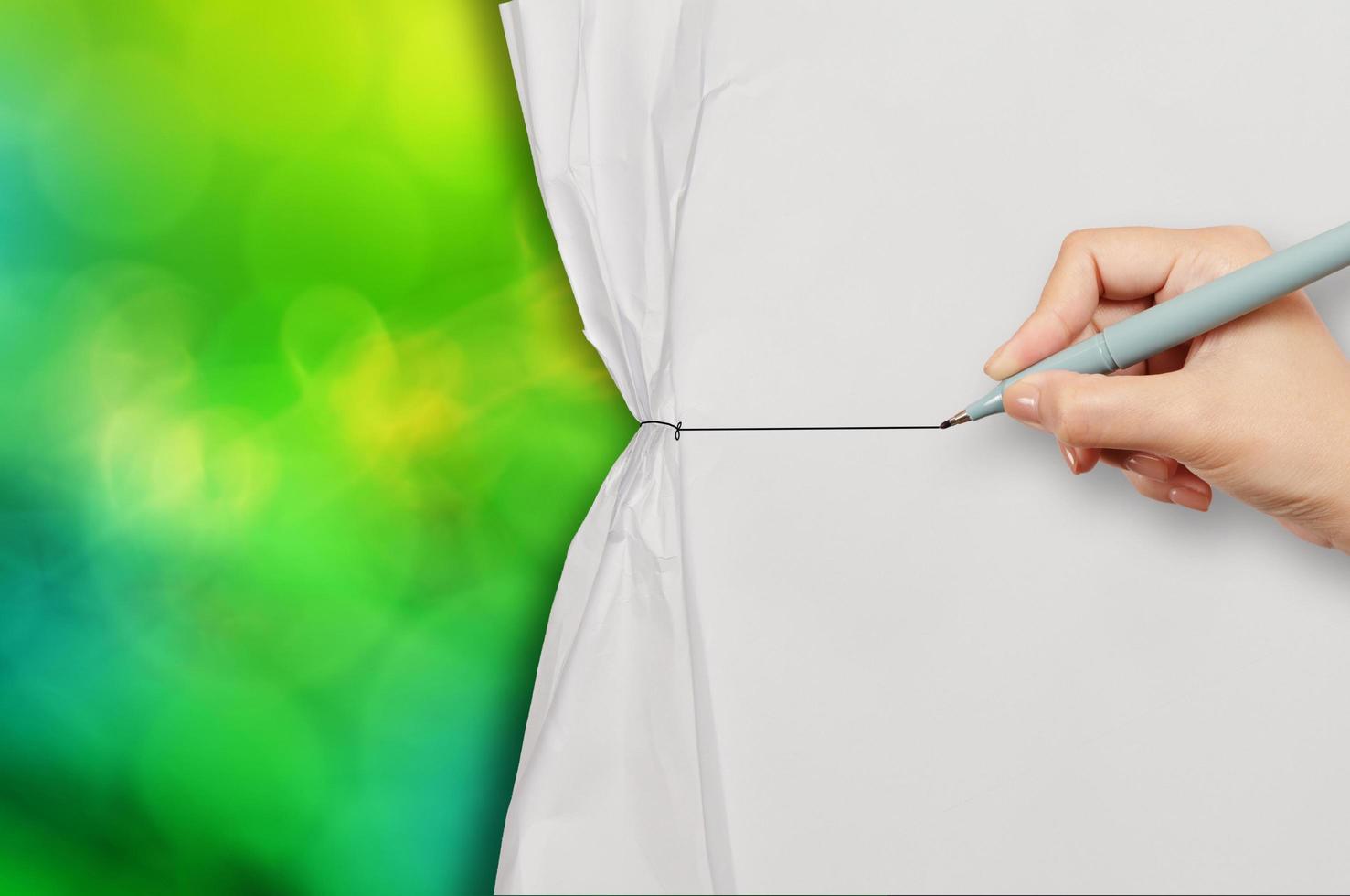 hand drawing rope to open crumpled paper to show green nature background as  concept photo