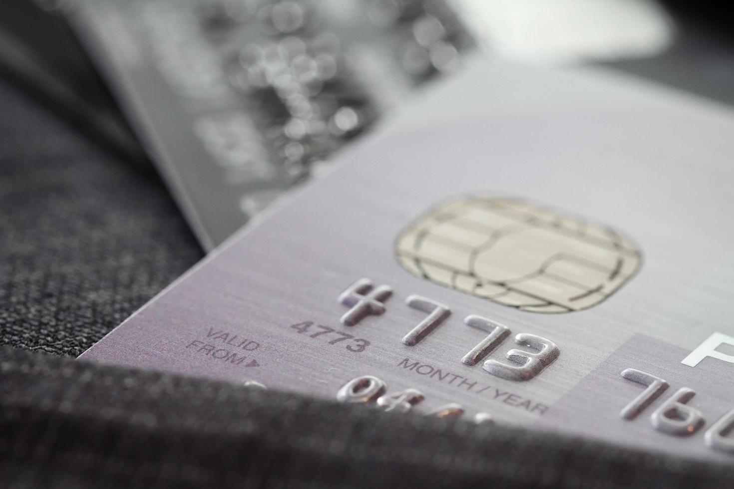 tarjetas de crédito en un enfoque muy superficial con fondo de traje gris foto