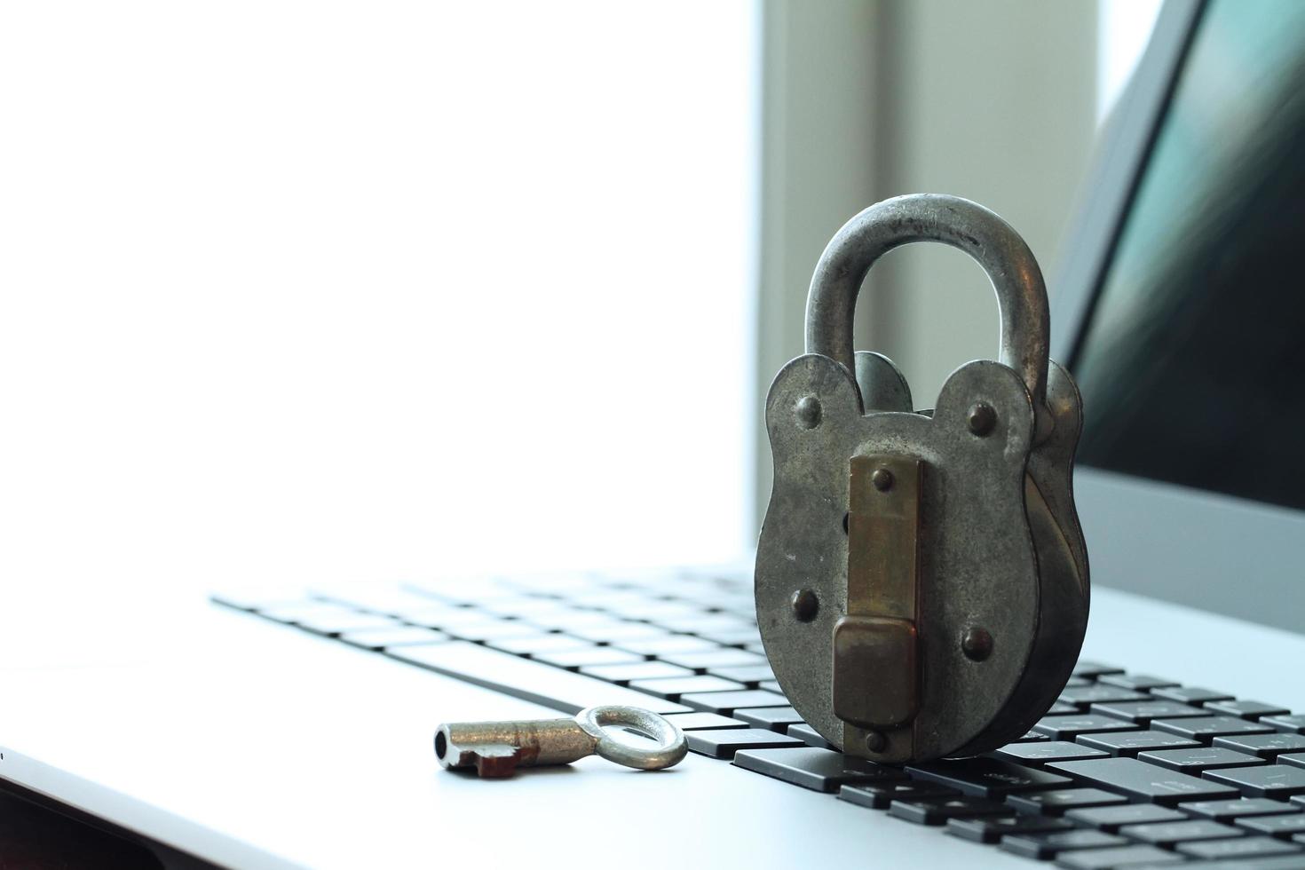 concepto de seguridad en Internet: candado antiguo y llave en el teclado de la computadora portátil foto