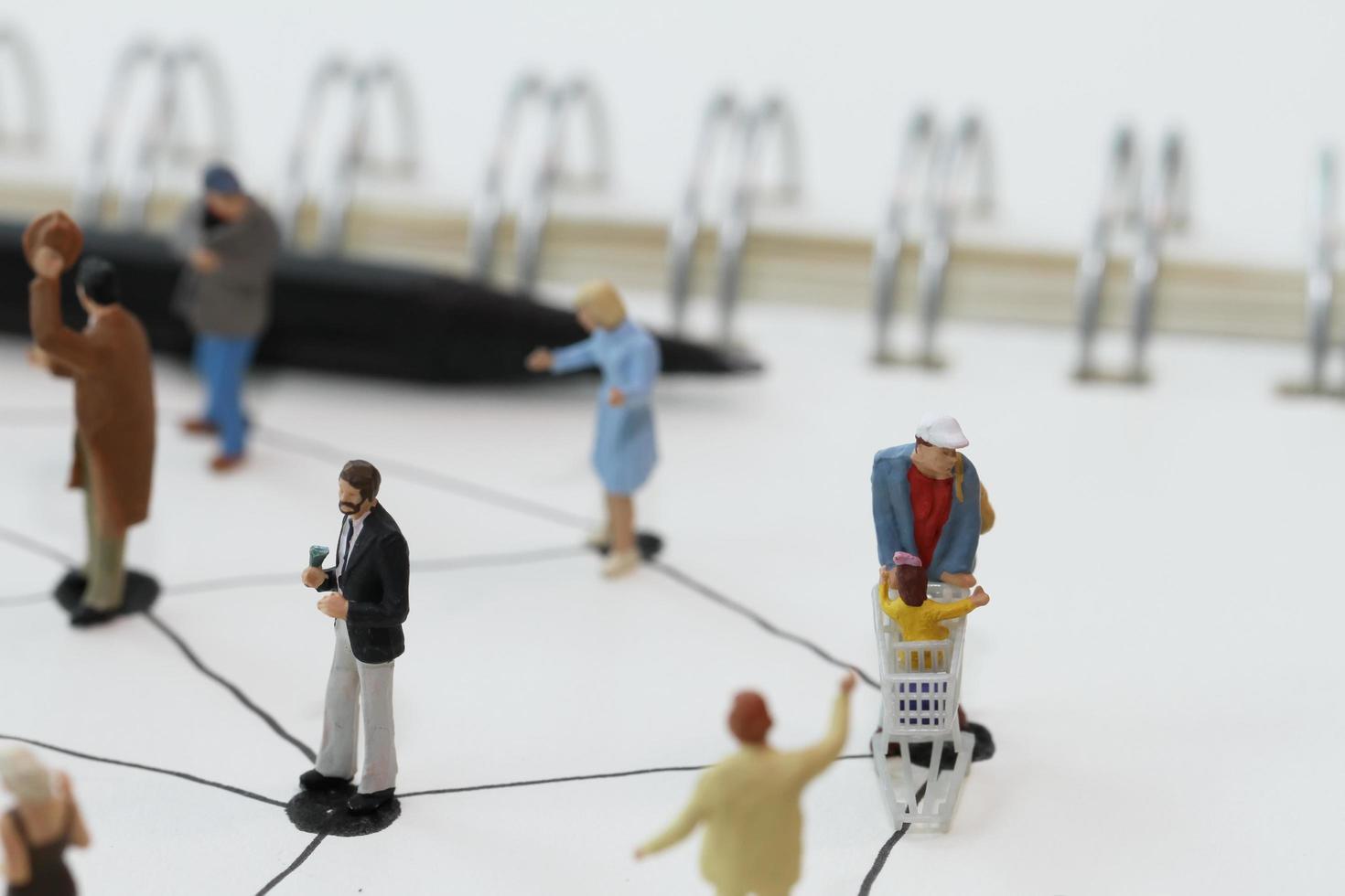 close up of miniature people with social network diagram on open notebook on wooden desk as social media concept photo