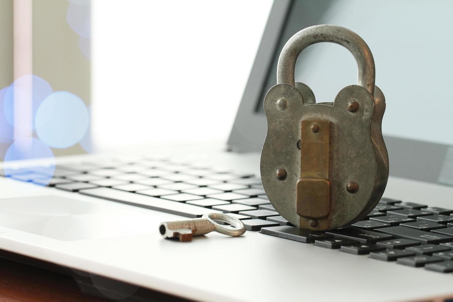 Internet security concept-old key and padlock on laptop computer keyboard photo