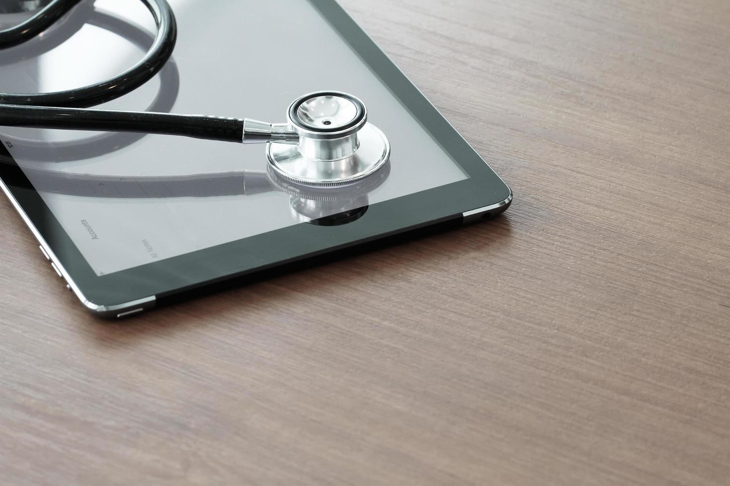 Studio macro of a stethoscope and digital tablet with shallow DOF evenly matched abstract on wood table background copy space photo