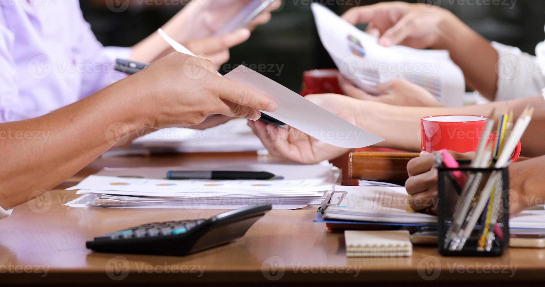 Asian businesswomen analysis documents on office table with laptop computer and graph financial diagram working in the background photo