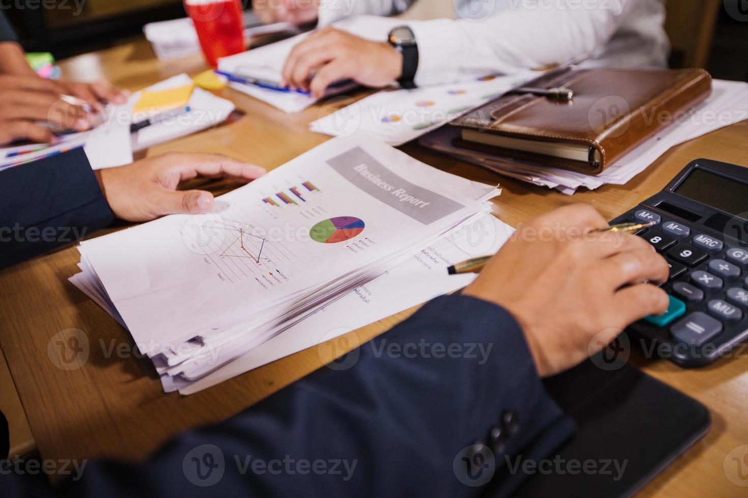 Businessmen are using calculators and analysis business data and and graph financial diagram working  at the meeting. photo