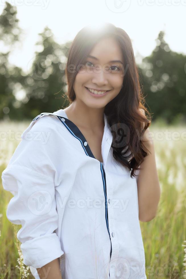 Asian women happy smile on relaxing time at the meadow and grass photo