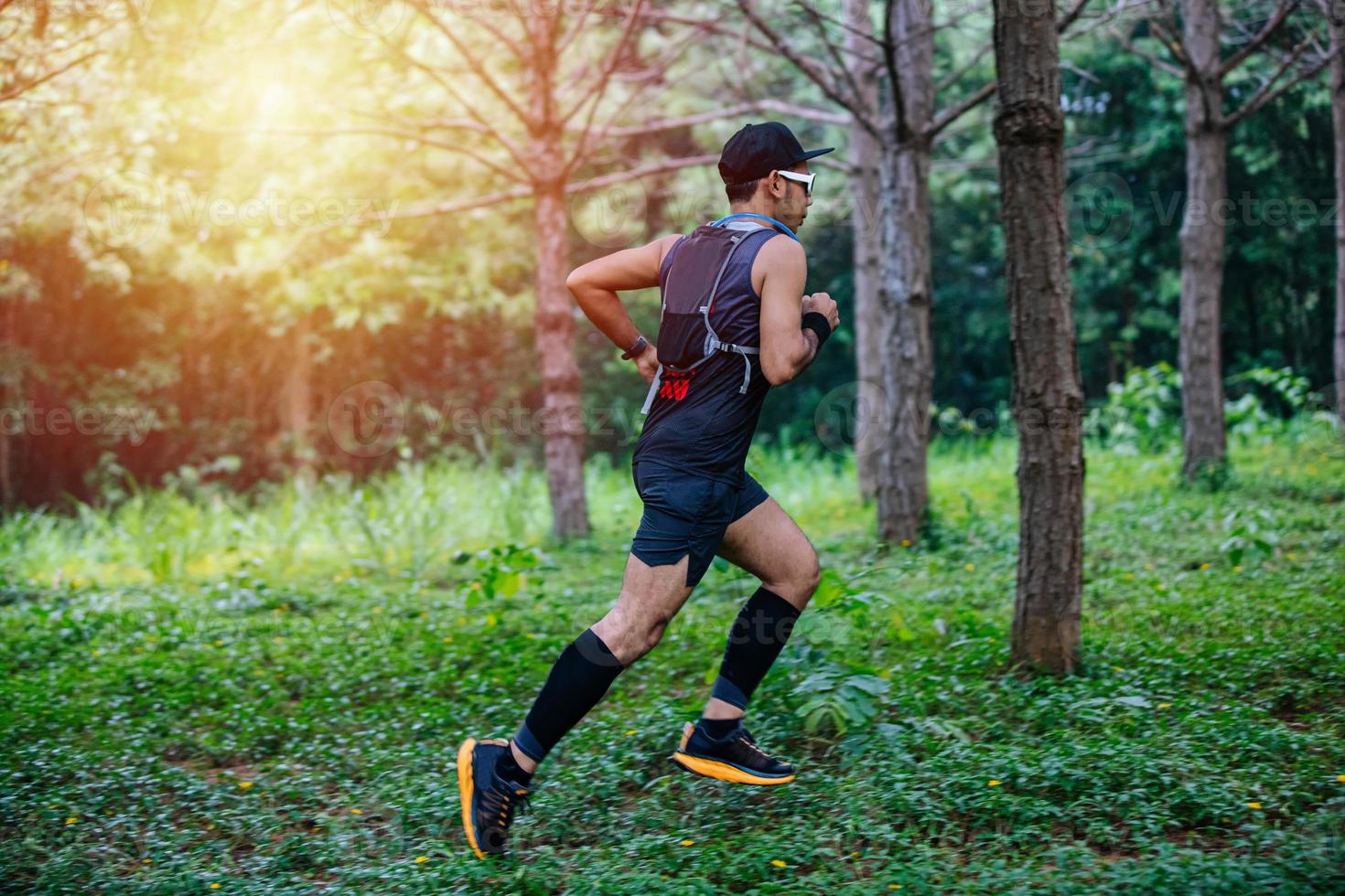 A man Runner of Trail and athlete's feet wearing sports shoes for trail running in the forest photo