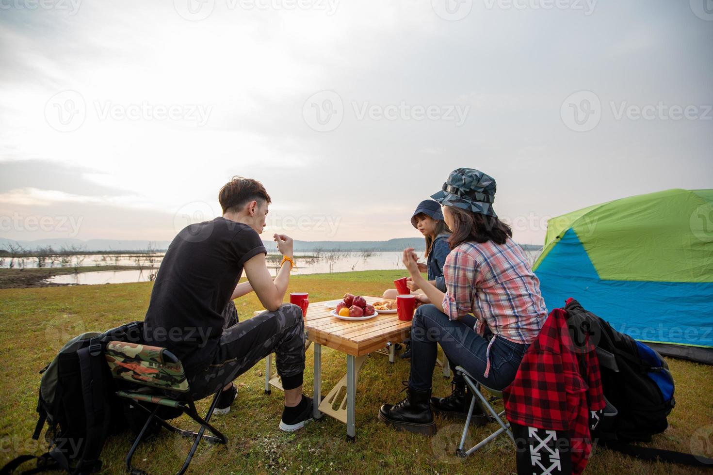 A group of Asian friends drinking coffee and spending time making a picnic in the summer holidays.They are happy and have fun on holidays. photo