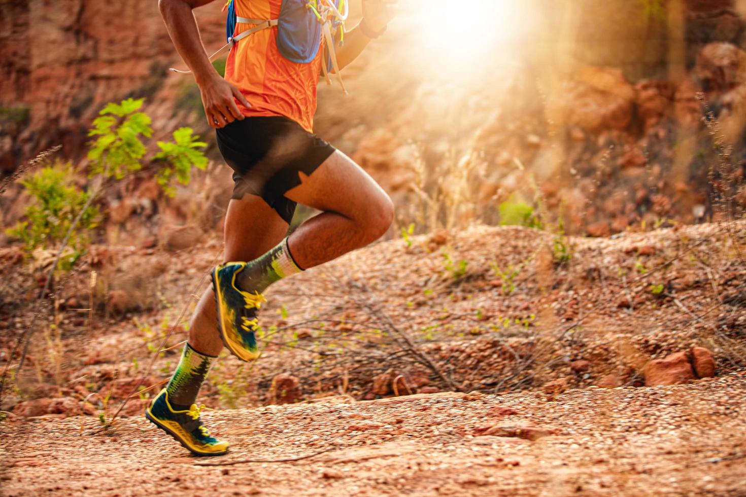 A man Runner of Trail . and athlete's feet wearing sports shoes for trail running in the mountains , soft focus and blurry photo