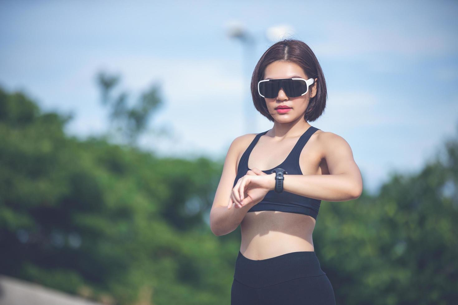 Female runner checking smart watch fitness tracker and smiling after Jogging and Runners legs photo