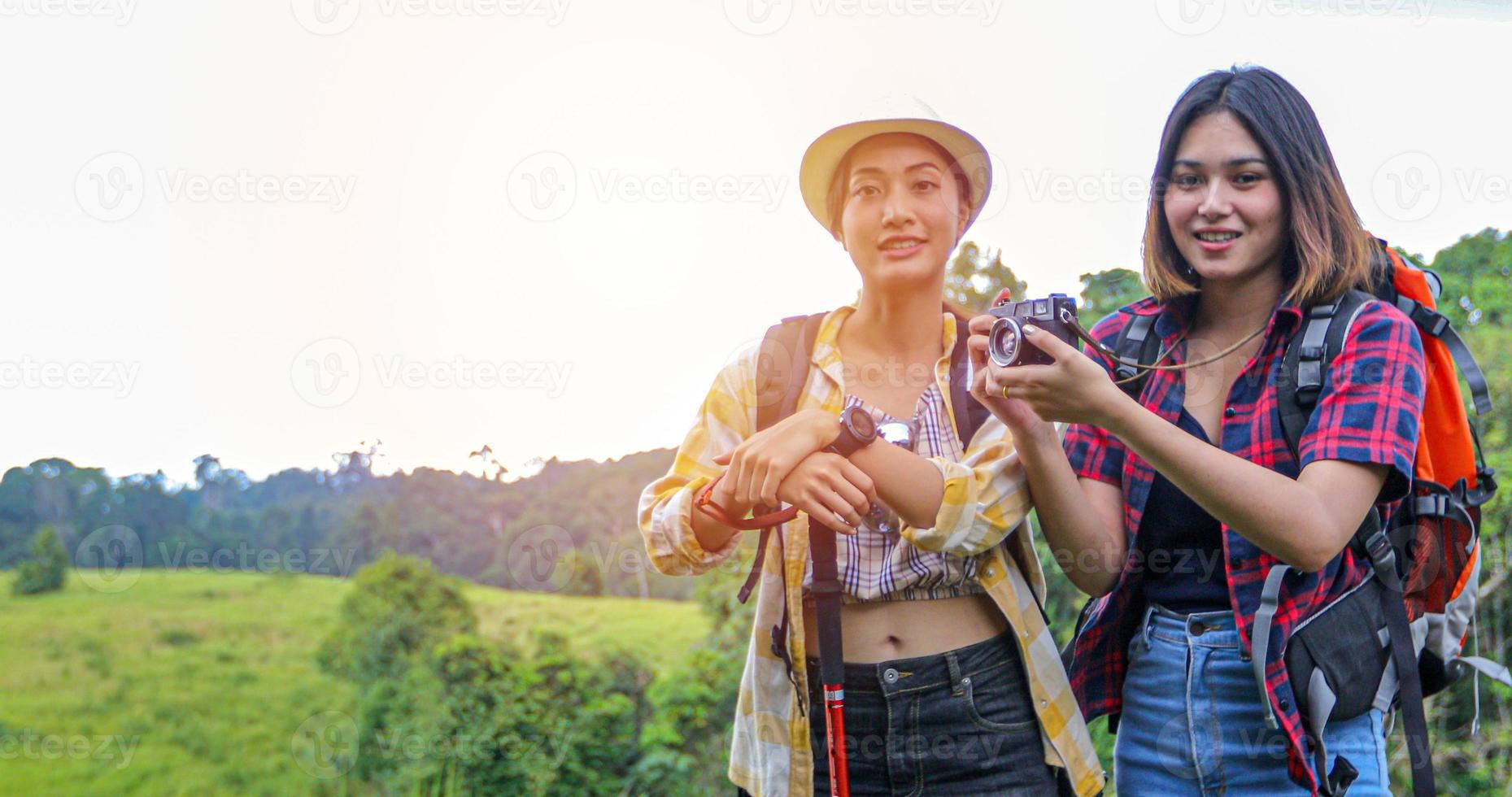 Asian Group of young people Hiking with friends backpacks walking together and looking map and taking photo camera by the road and looking happy ,Relax time on holiday concept travel