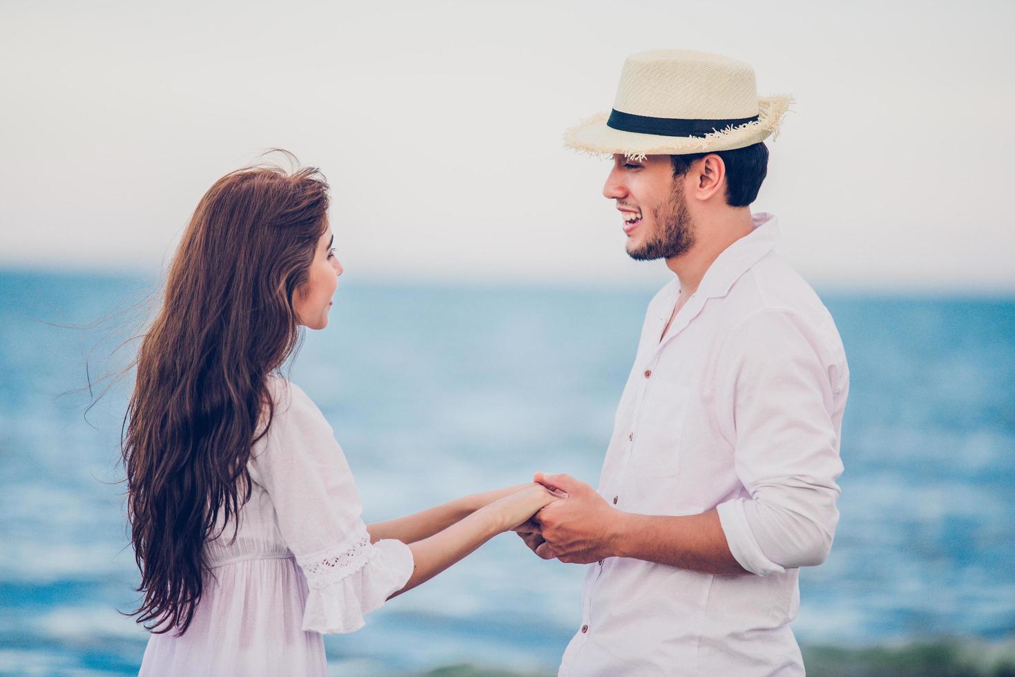 Happy Romantic Couples lover holding hands together walking on the beach photo