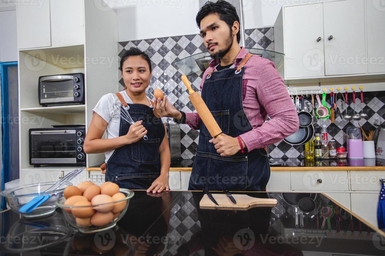 Happy and Smiling young couple cooking food in the kitchen at home photo