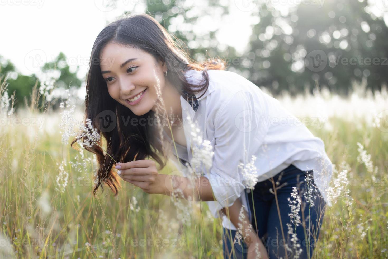 Asian women happy smile on relaxing time at the meadow and grass photo