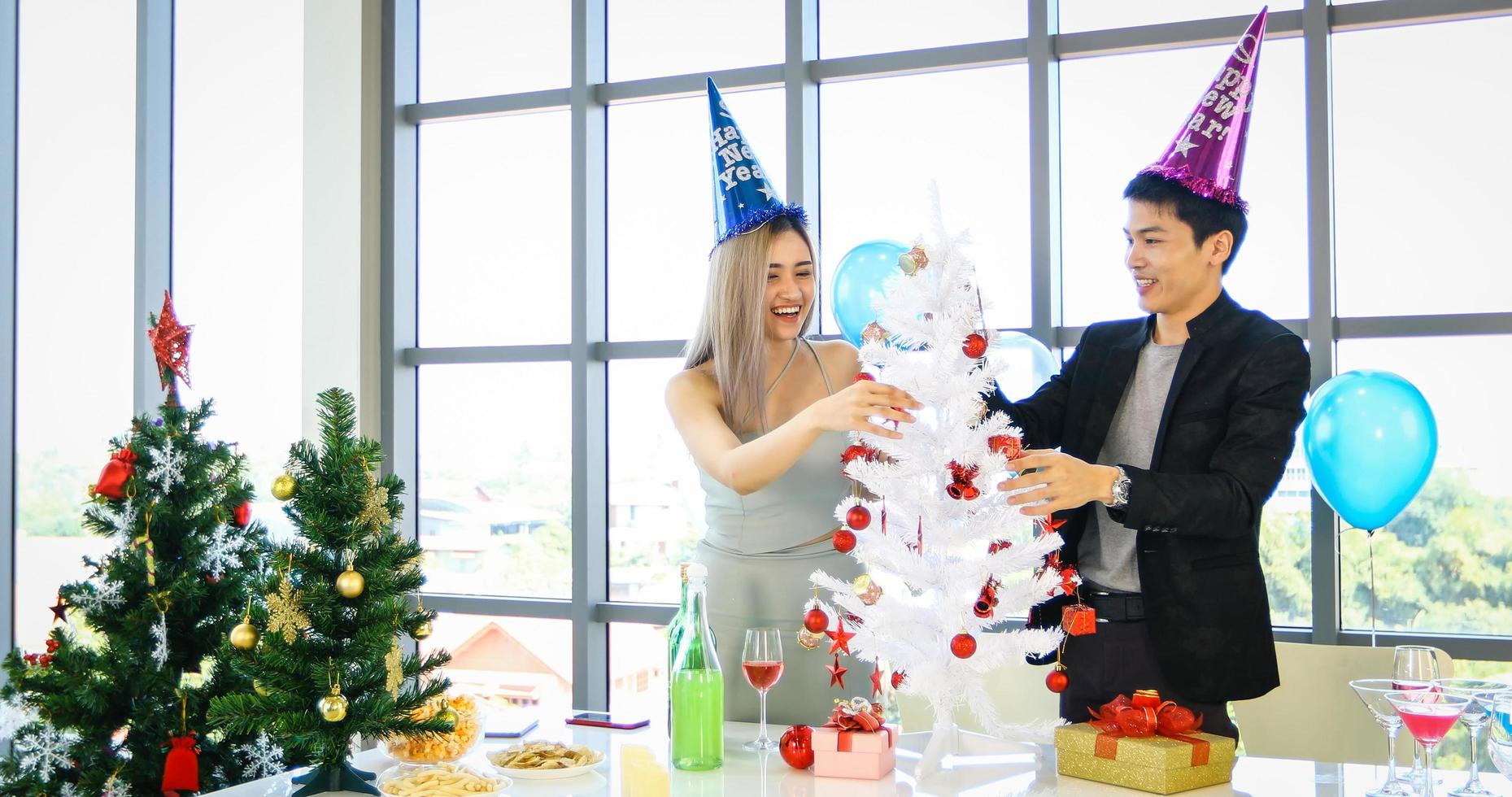 pareja asiática amante de la fiesta con bebidas alcohólicas de cerveza y jóvenes disfrutando en un bar brindando cócteles con regalo de navidad en vacaciones de navidad y feliz patty de año nuevo foto