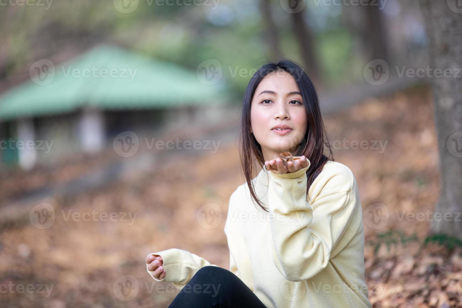 Hermosa mujer asiática sonriente niña feliz y vistiendo ropa abrigada retrato de invierno y otoño al aire libre en el parque foto