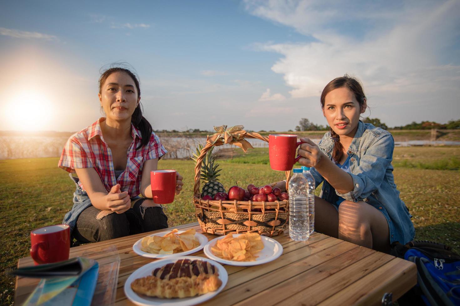 A group of Asian friends drinking coffee and spending time making a picnic in the summer holidays.They are happy and have fun on holidays. photo