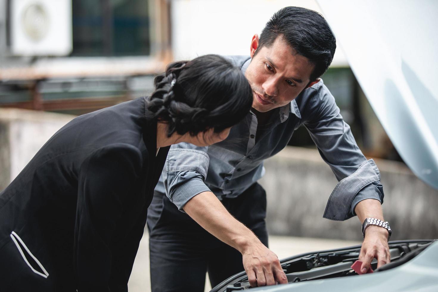 Los empresarios ayudan a las empresarias a comprobar y reparar coches rotos. foto