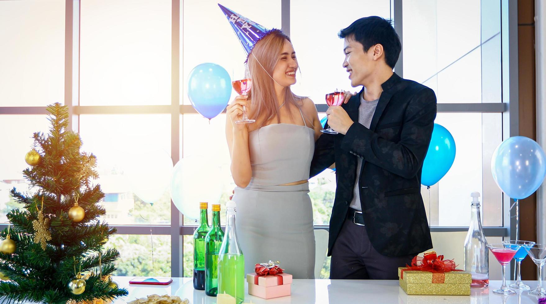 pareja asiática amante de la fiesta con bebidas alcohólicas de cerveza y jóvenes disfrutando en un bar brindando cócteles con regalo de navidad en vacaciones de navidad y feliz patty de año nuevo foto