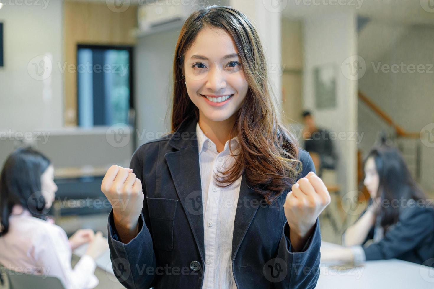 Asian  businesswomen Success and winning concept - happy team with raised up hands celebrating the breakthrough and achievements photo