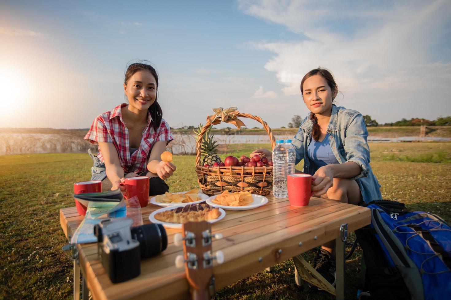 A group of Asian friends drinking coffee and spending time making a picnic in the summer holidays.They are happy and have fun on holidays. photo