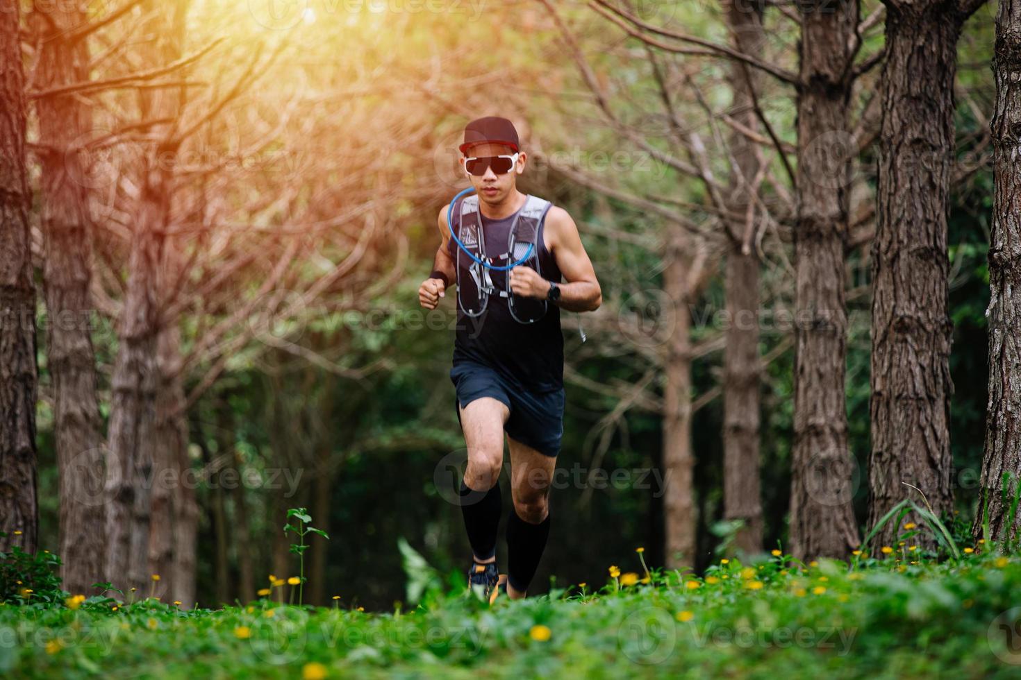 A man Runner of Trail and athlete's feet wearing sports shoes for trail running in the forest photo