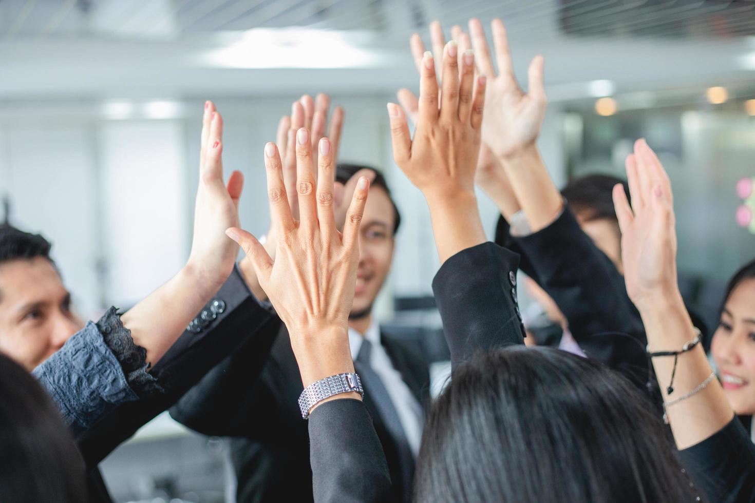 Happy Business people showing team work and giving five after signing agreement or contract with foreign partners in office interior. photo