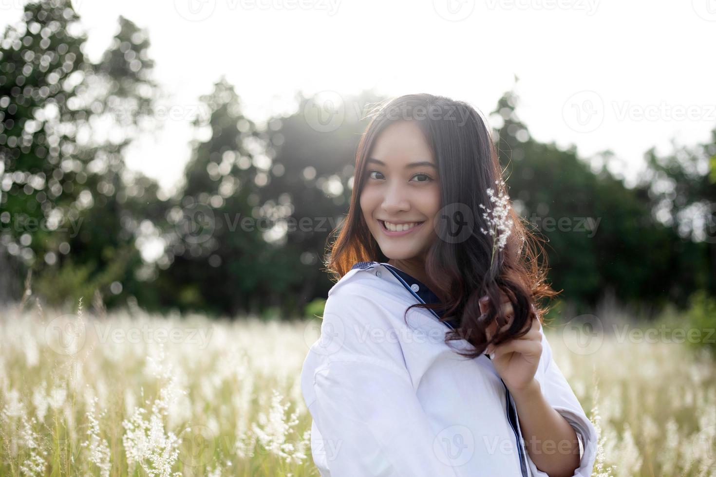 Asian women happy smile on relaxing time at the meadow and grass photo