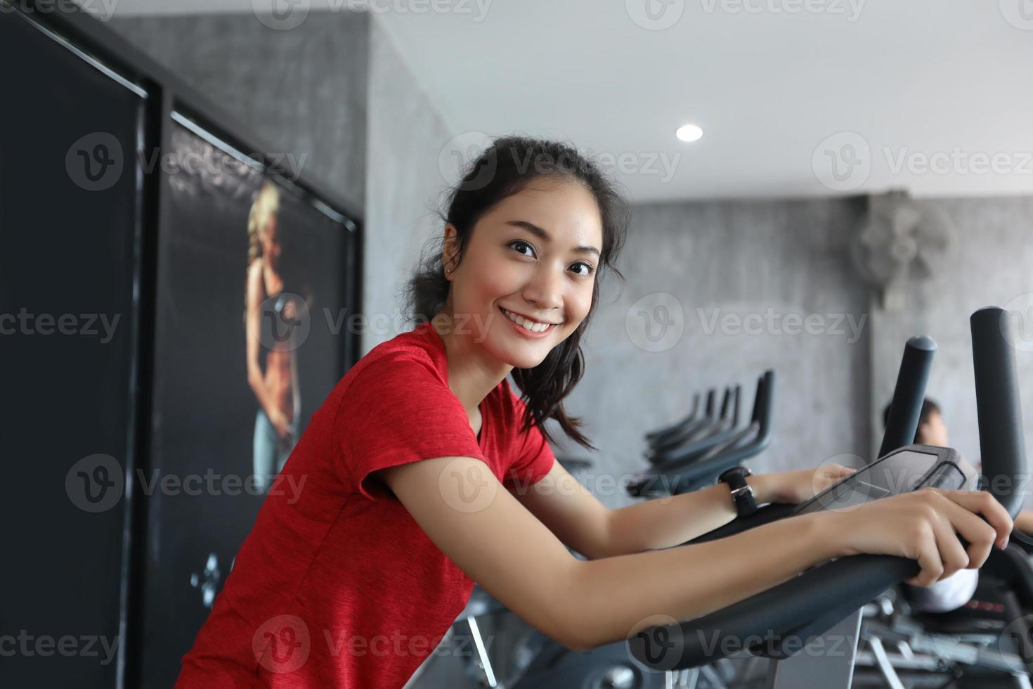 mujer en bicicleta de gimnasio haciendo ejercicio cardiovascular. foto