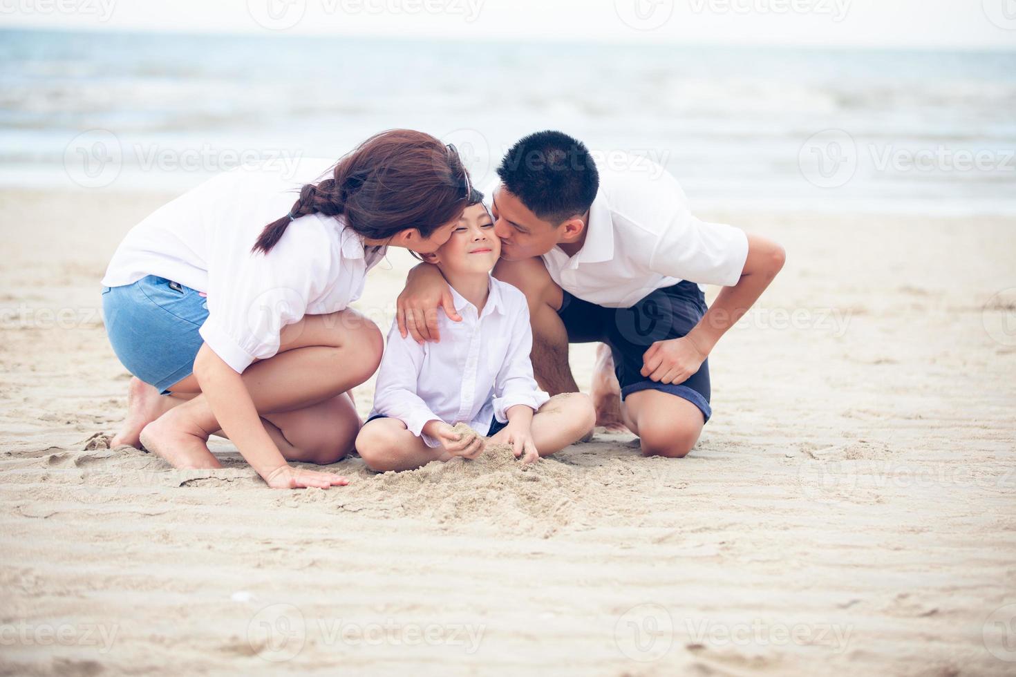 padres activos y personas actividad al aire libre en vacaciones de verano y vacaciones con niños.Familia feliz e hijo caminan con la diversión del mar al atardecer en la playa de arena. foto