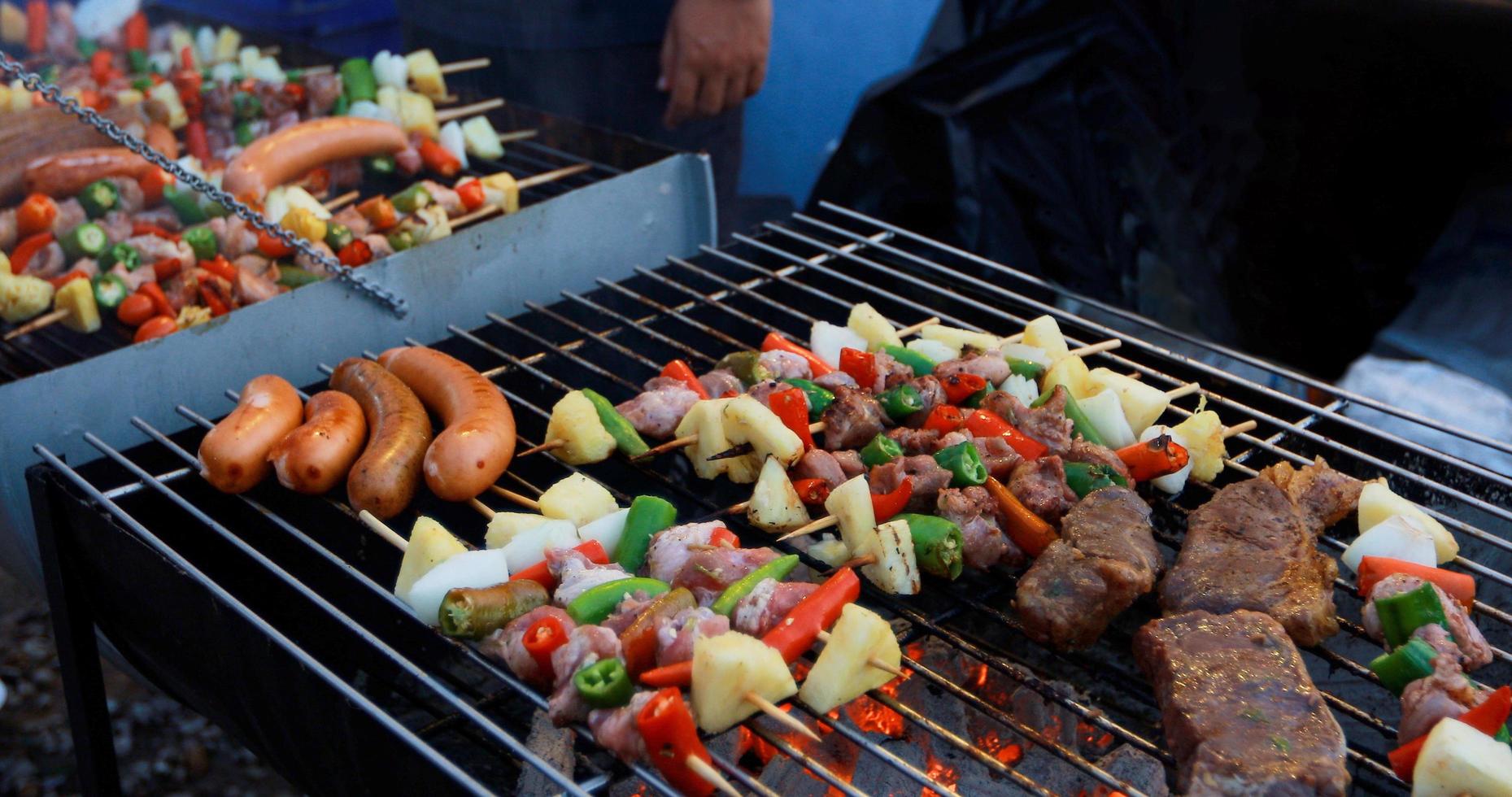 Grupo asiático de amigos con barbacoa en el jardín al aire libre riendo con bebidas alcohólicas de cerveza en la noche foto