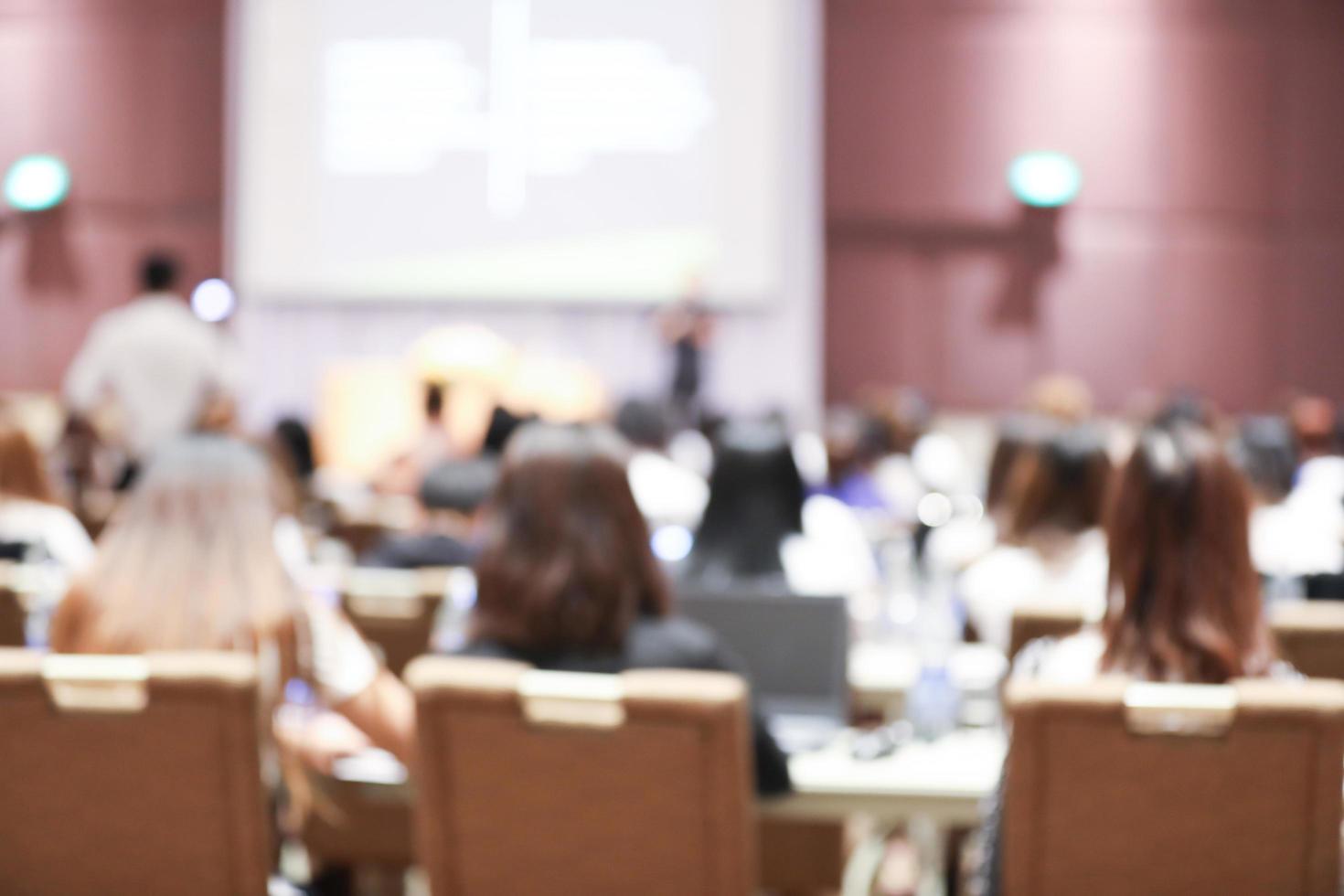 Abstract blurry background of employees seminar and De-focus teamwork staffs working meeting in conference room with projector screen. photo