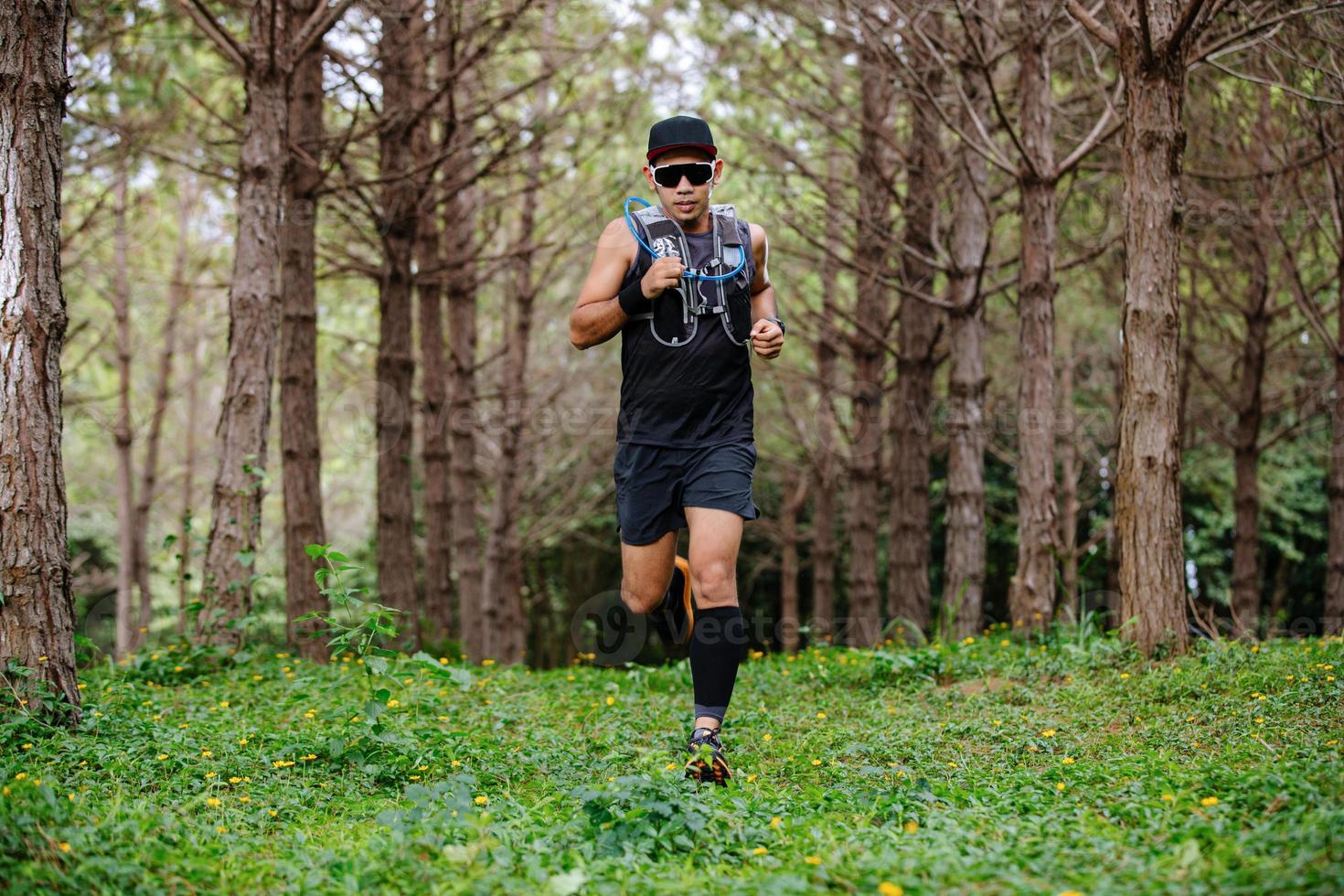 A man Runner of Trail and athlete's feet wearing sports shoes for trail running in the forest photo