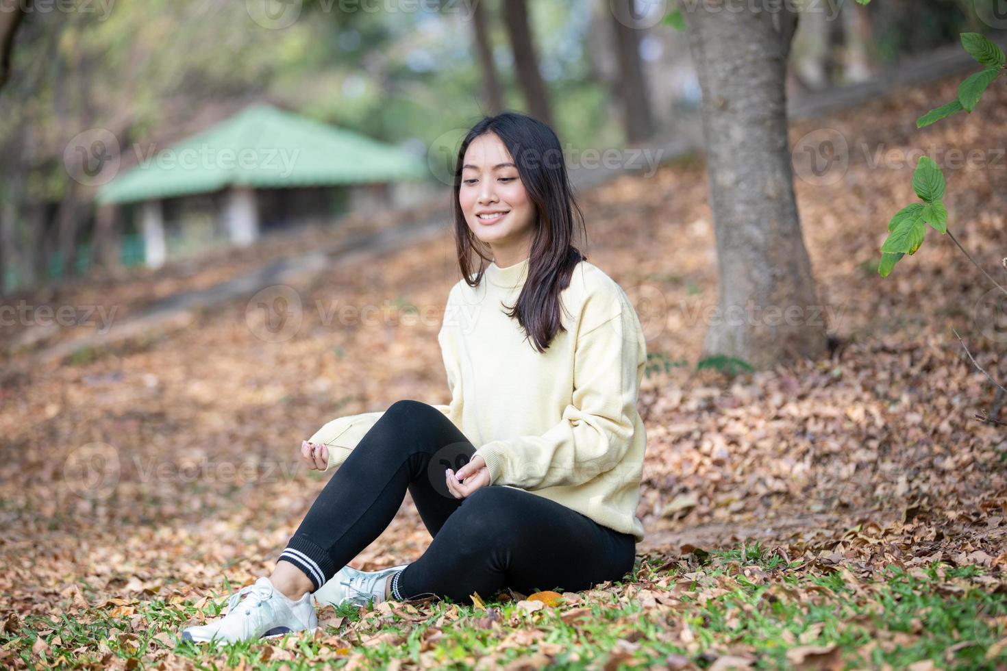 Hermosa mujer asiática sonriente niña feliz y vistiendo ropa abrigada retrato de invierno y otoño al aire libre en el parque foto