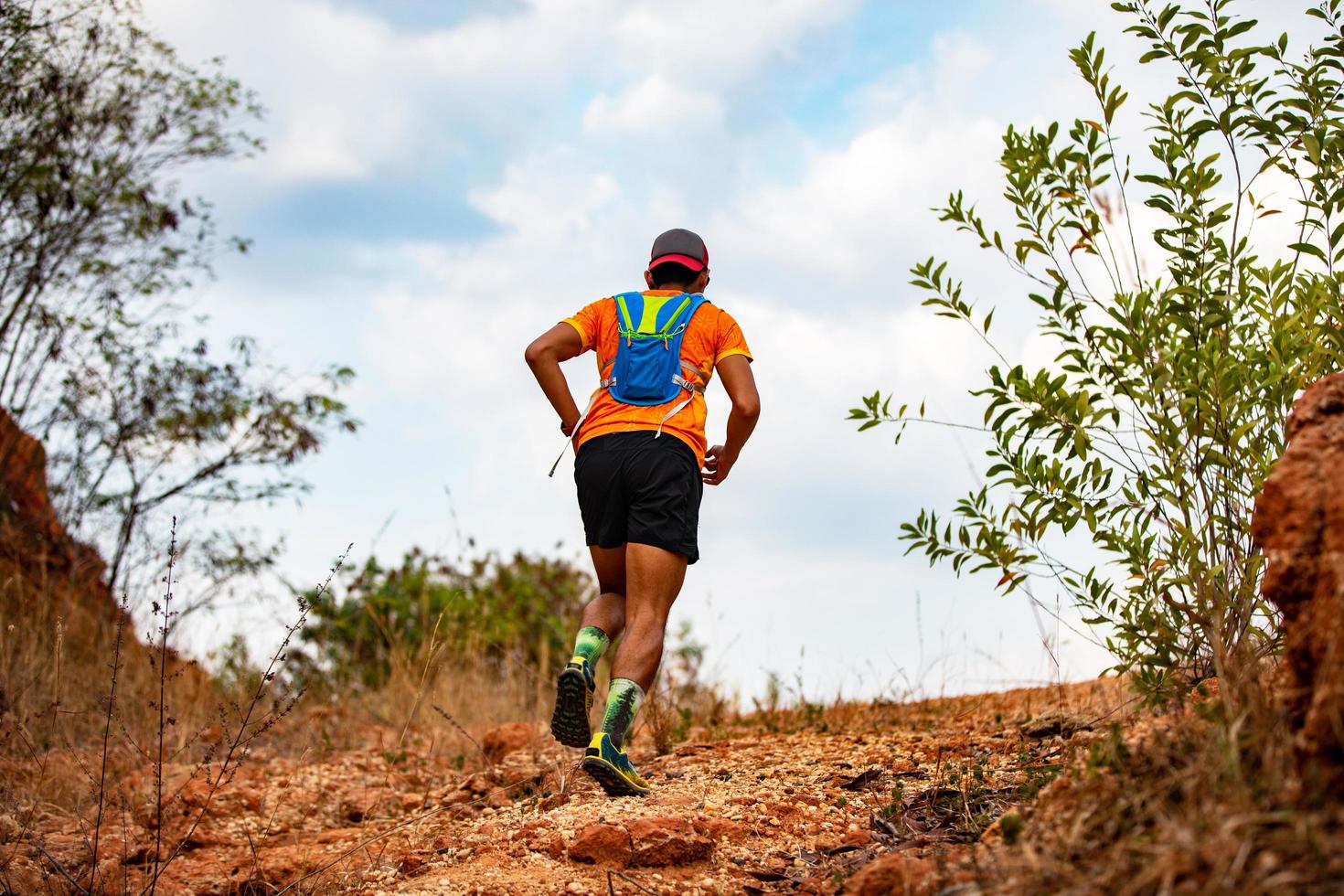 A man Runner of Trail . and athlete's feet wearing sports shoes for trail running in the mountains photo