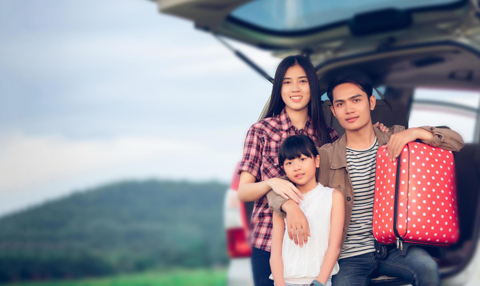 Happy little girl  with asian family sitting in the car for enjoying road trip and summer vacation in camper van photo