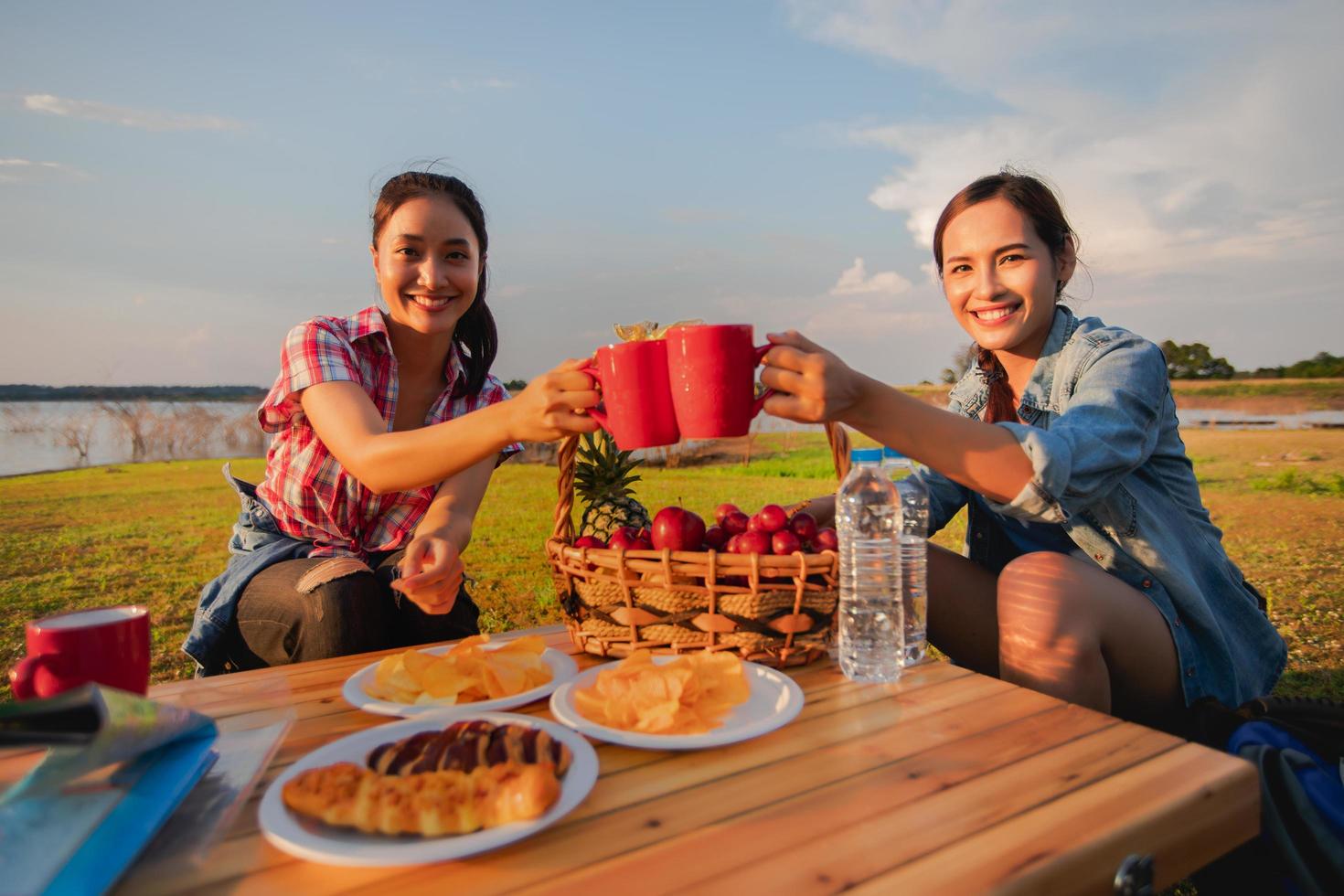 A group of Asian friends drinking coffee and spending time making a picnic in the summer holidays.They are happy and have fun on holidays. photo