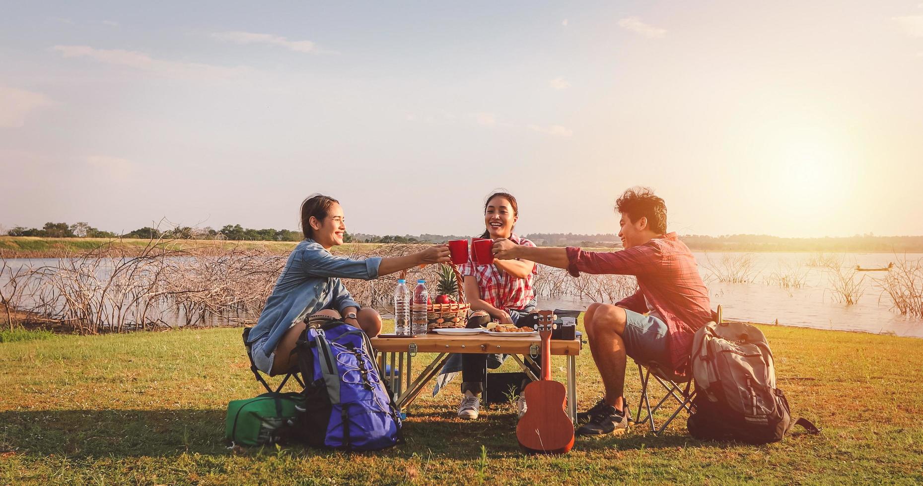 A group of Asian friends drinking coffee and spending time making a picnic in the summer holidays.They are happy and have fun on holidays. photo