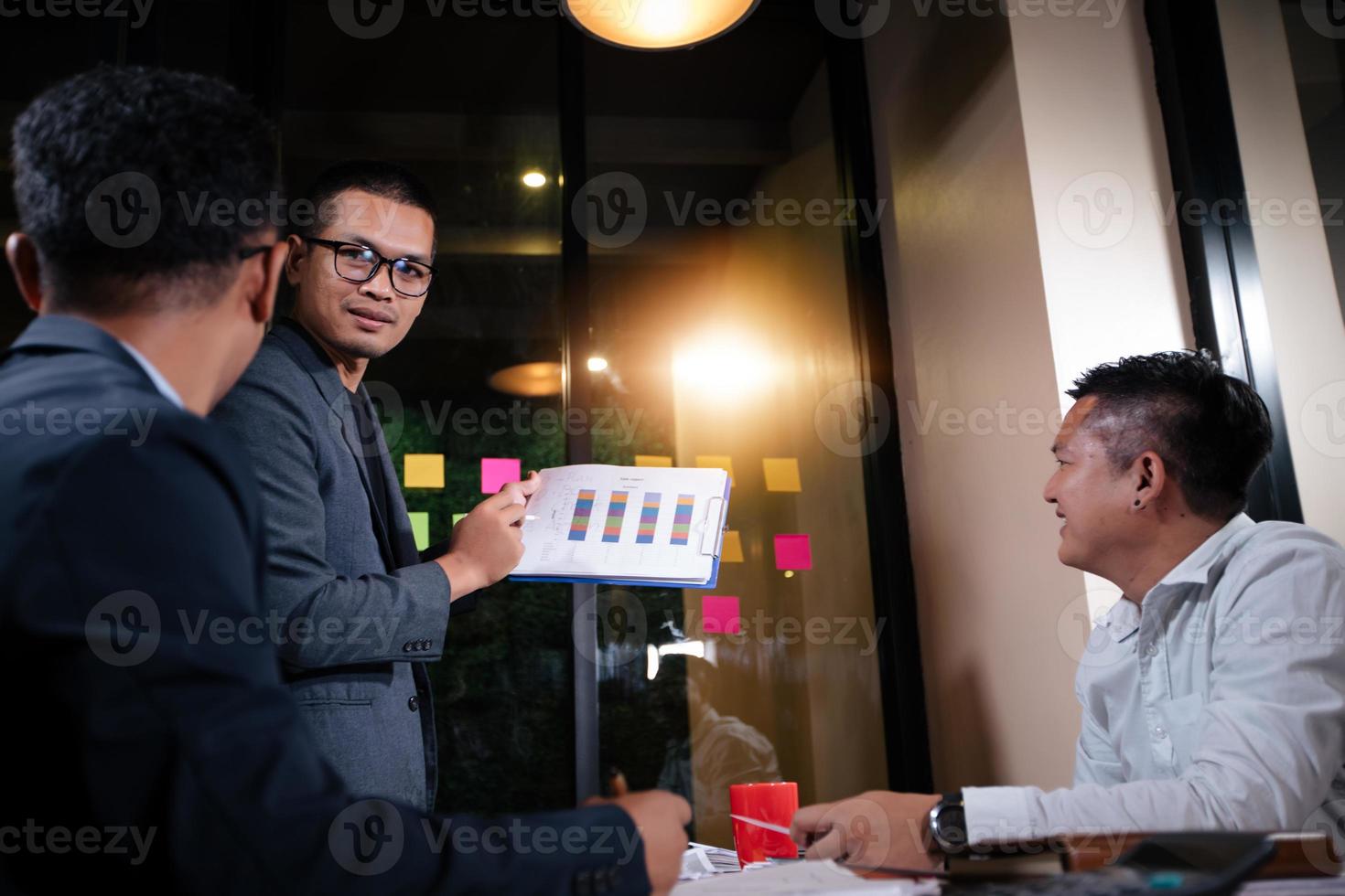 Asian businesswomen using tablet for analysis documents and graph financial diagram working in meeting photo