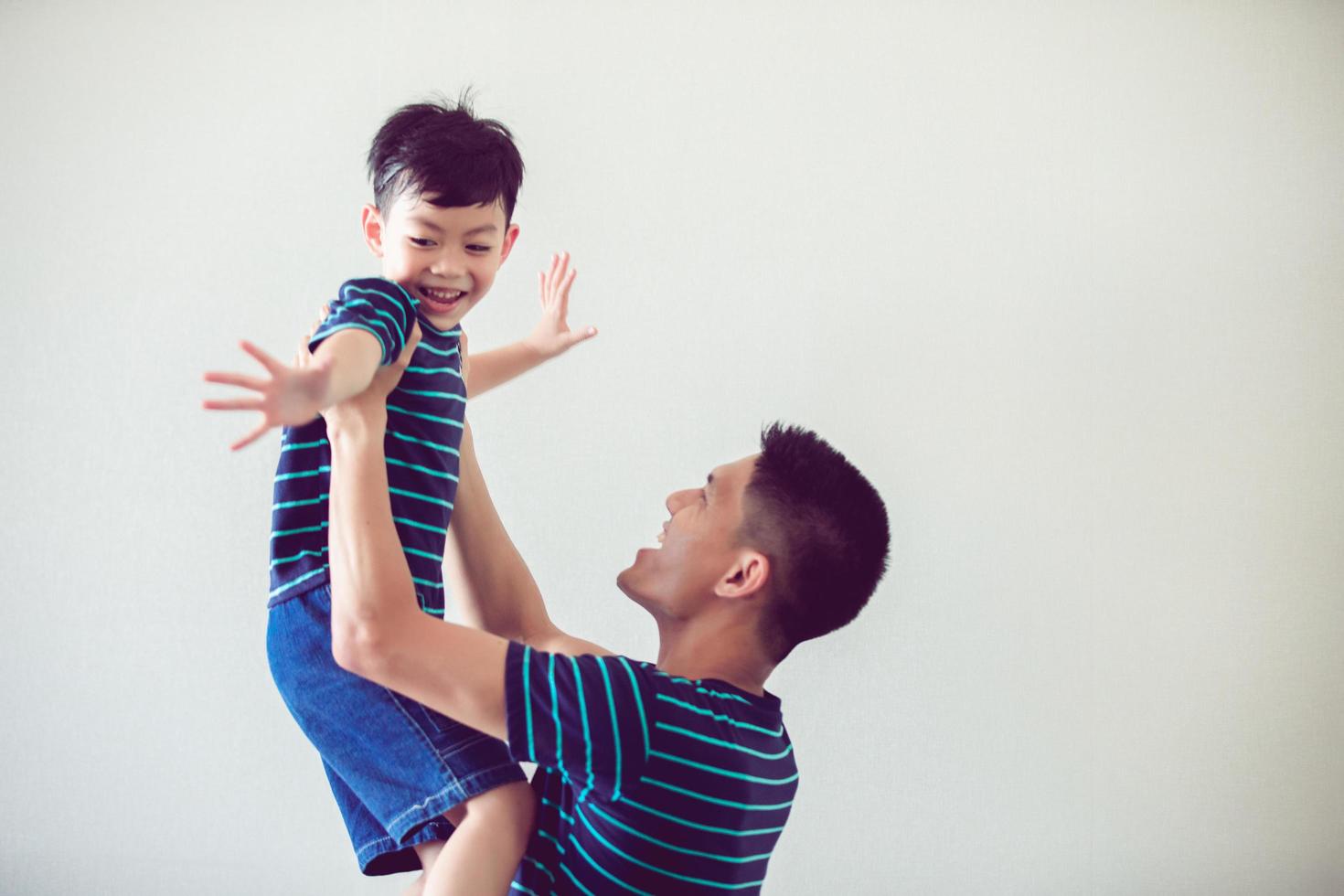 feliz familia asiática con hijo en casa y riendo foto