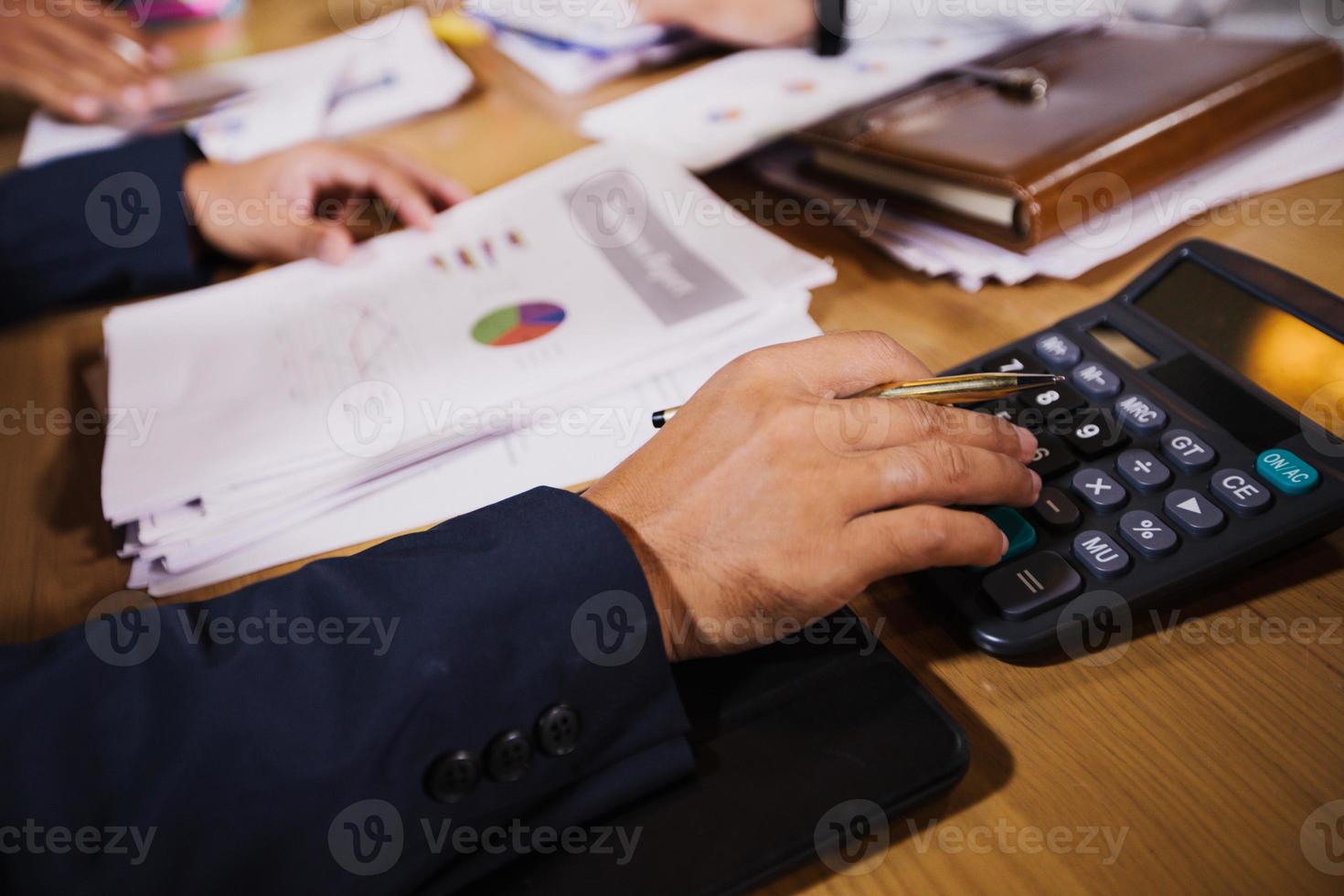 Businessmen are using calculators and analysis business data and and graph financial diagram working  at the meeting. photo