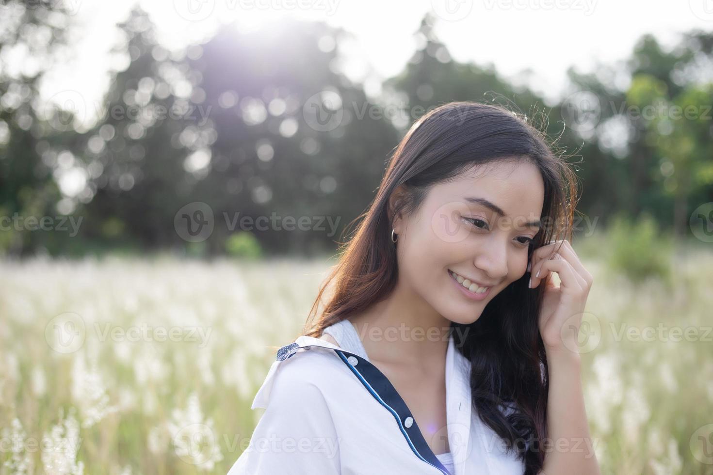 Asian women happy smile on relaxing time at the meadow and grass photo