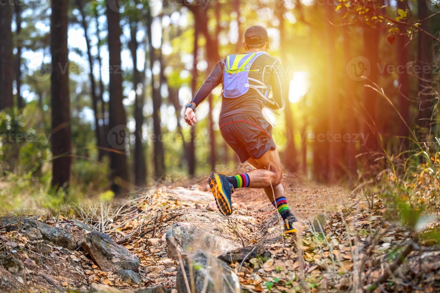 A man Runner of Trail and athlete's feet wearing sports shoes for trail running in the forest photo