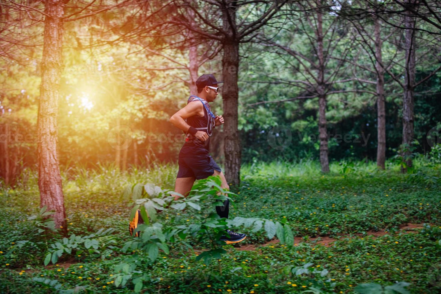 A man Runner of Trail and athlete's feet wearing sports shoes for trail running in the forest photo