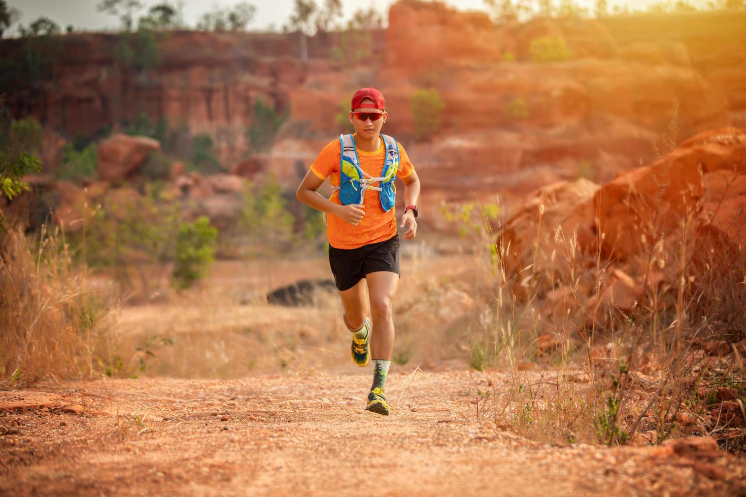 A man Runner of Trail and athlete's feet wearing sports shoes for trail running in the forest photo