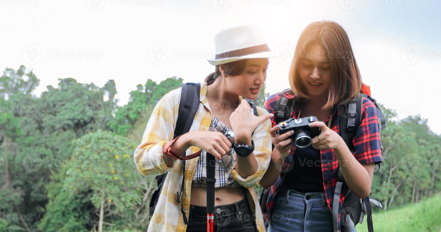 Asian Group of young people Hiking with friends backpacks walking together and looking map and taking photo camera by the road and looking happy ,Relax time on holiday concept travel