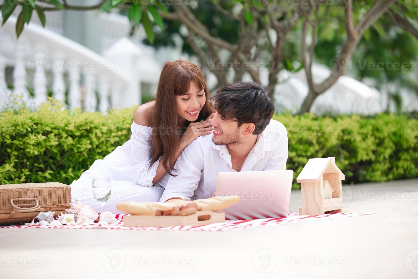 Happy Romantic Couples lover talking and drinking wine while having a picnic at home photo