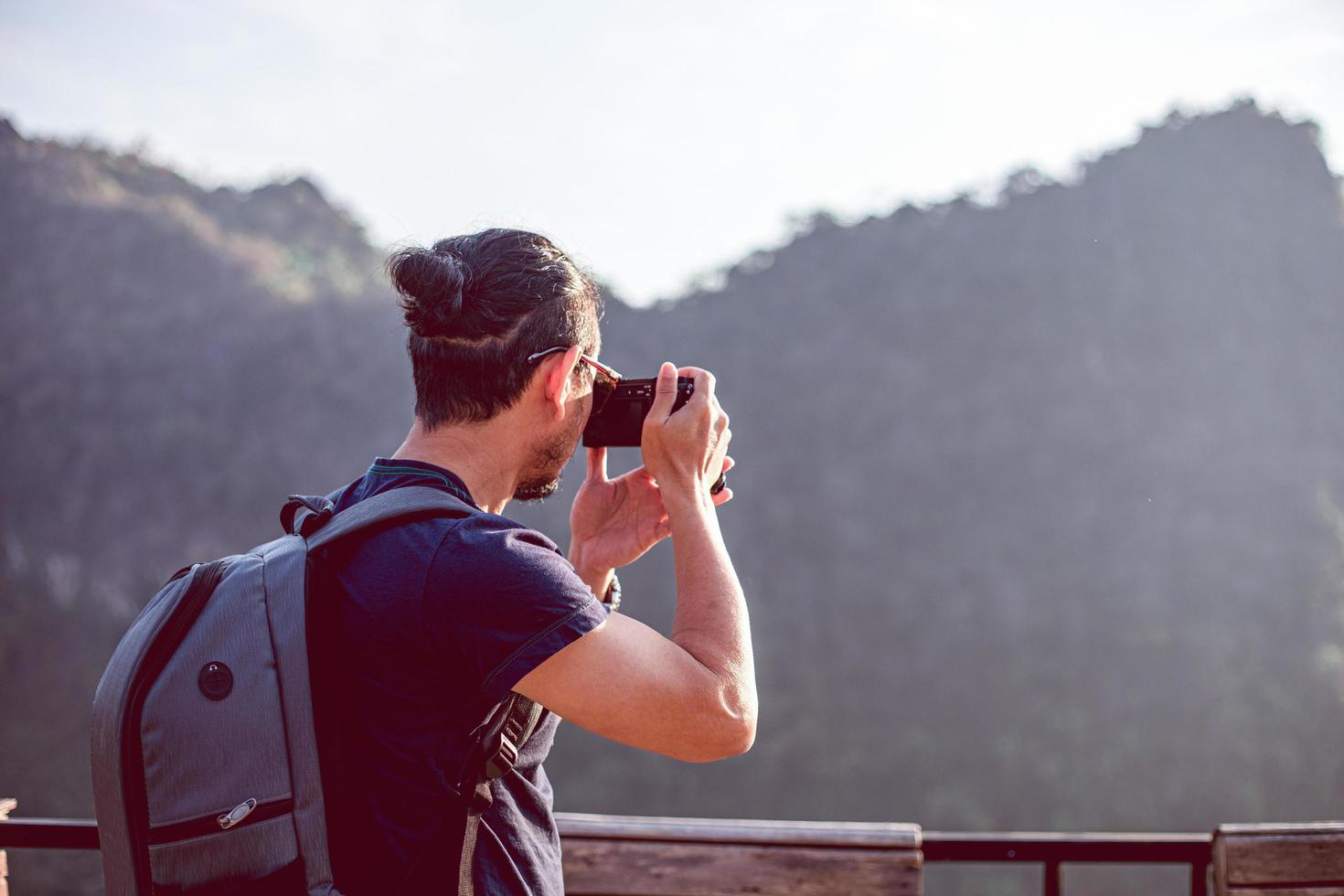 Asian men backpacks and traveler walking together and happy are taking photo on mountain  ,Relax time on holiday concept travel