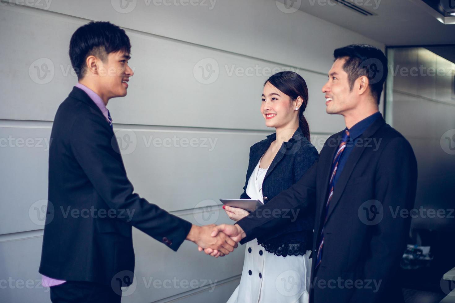 Business people shaking hands and smiling their agreement to sign contract and finishing up a meeting photo