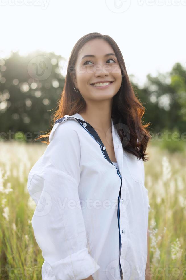 Asian women happy smile on relaxing time at the meadow and grass photo