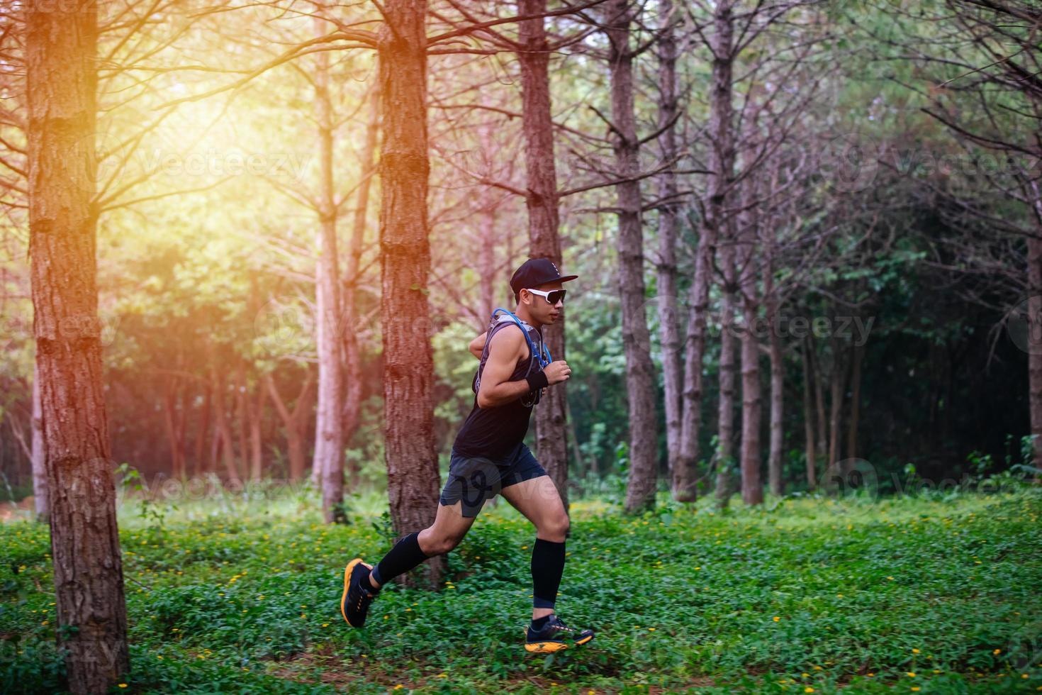 A man Runner of Trail and athlete's feet wearing sports shoes for trail running in the forest photo